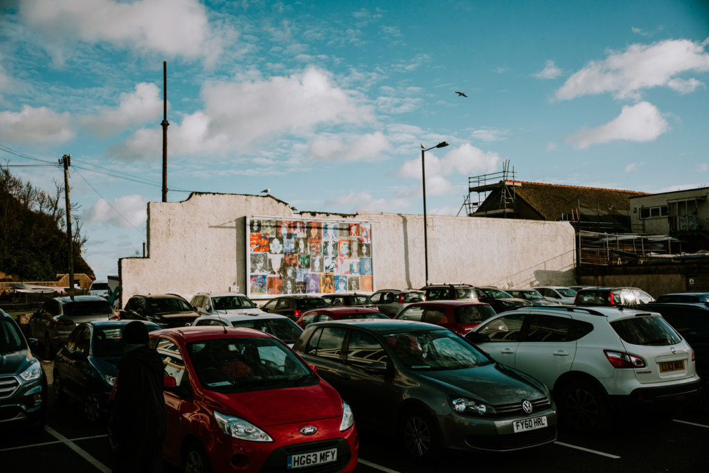 Cars in front of a wall with a picture on