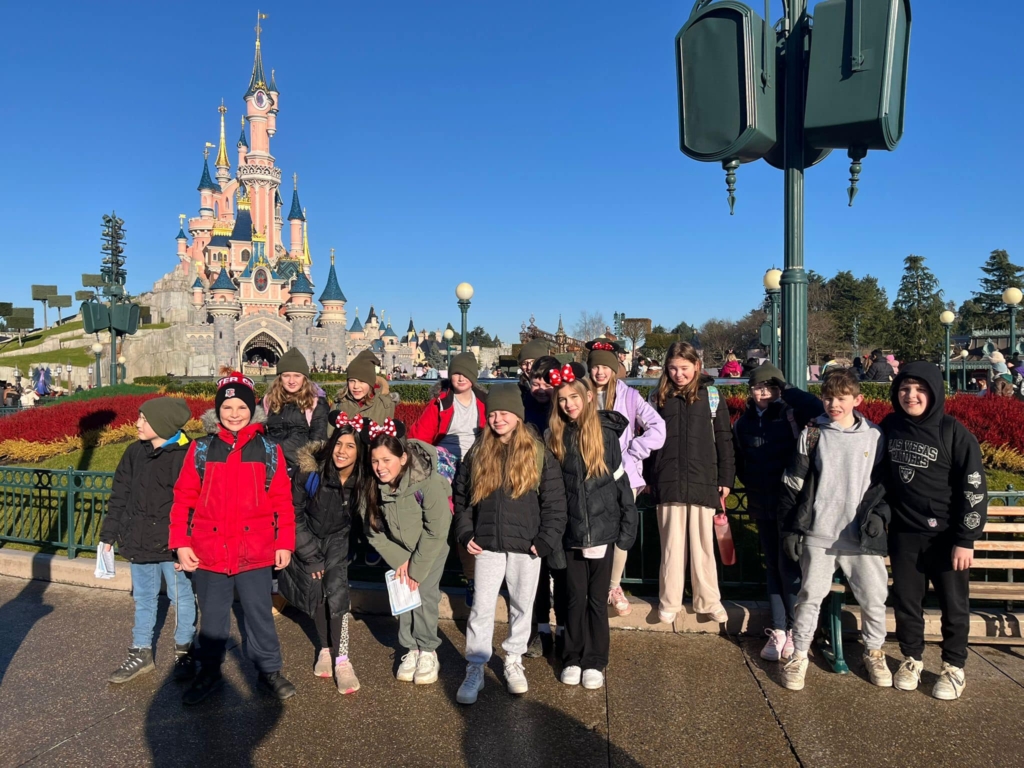 Exwick Heights Primary School stood in Disney Land Paris, with a magical castle in the background. 