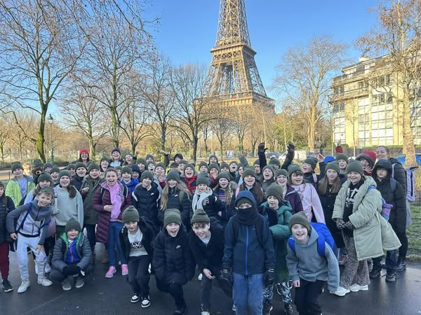 Exwick Heights Primary School stood in Paris with Eiffel Tower in the background.