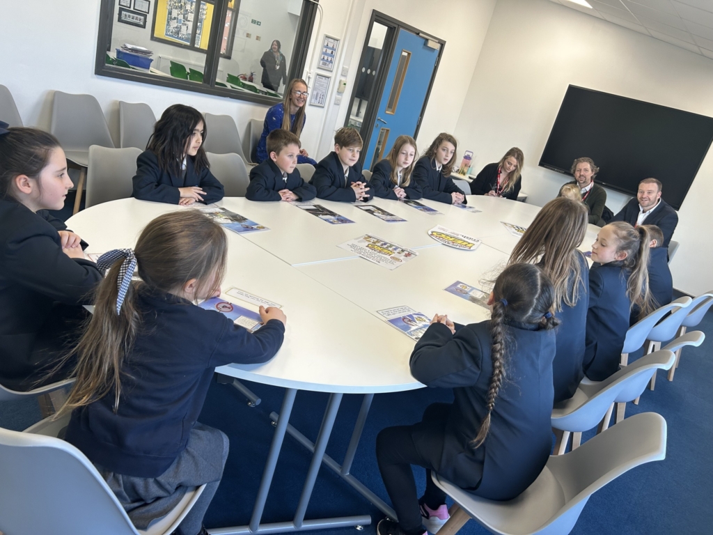 Marine Academy Primary  pupils sat at a table with MP Fred Thomas. 