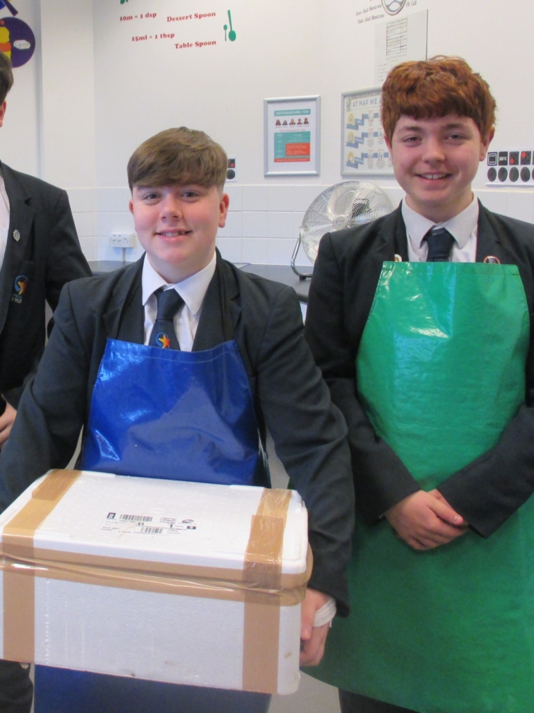 Two Marine Academy Plymouth Students holding a box of Mussels