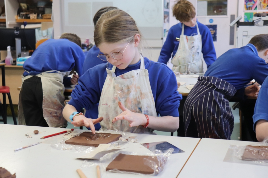 A Primary Pupil making a clay self-portrait at Sidmouth College