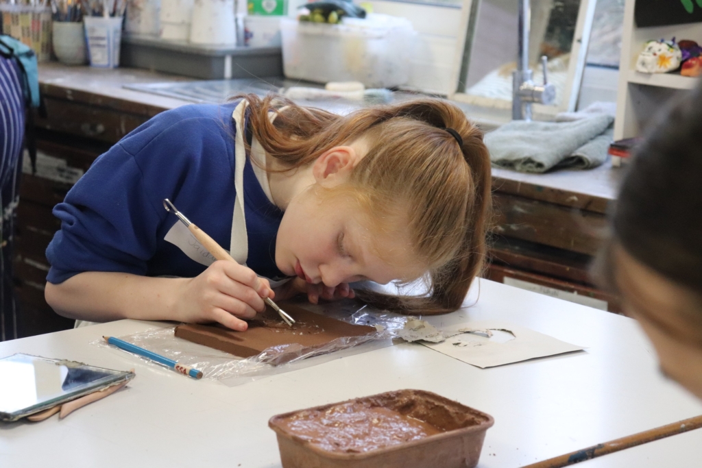 A Primary Pupil making a clay self-portrait at Sidmouth College