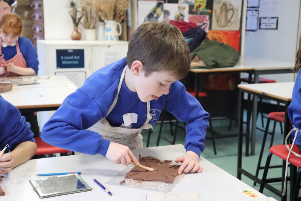 A Primary Pupil making a clay self-portrait at Sidmouth College