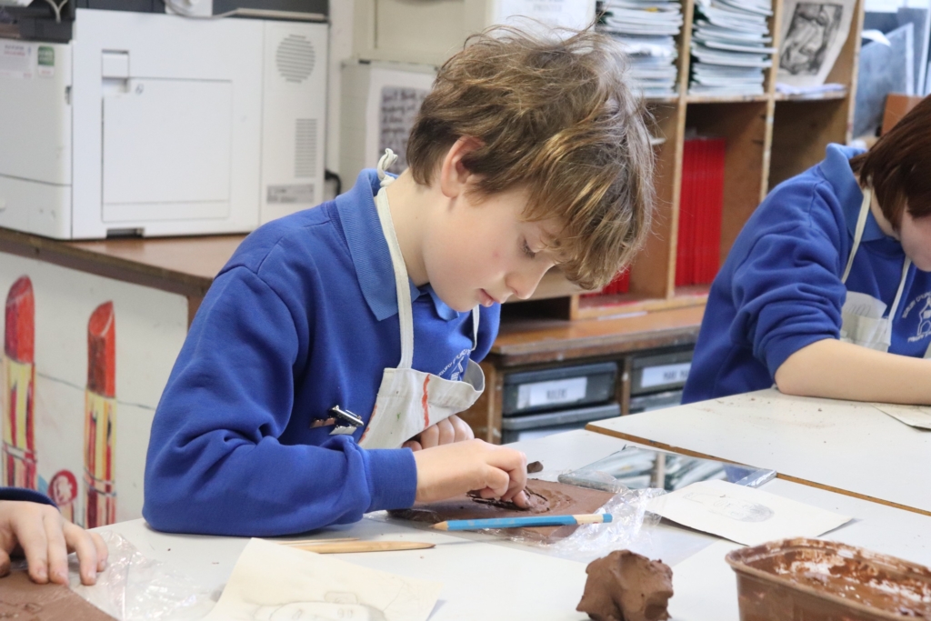 A Primary Pupil making a clay self-portrait at Sidmouth College