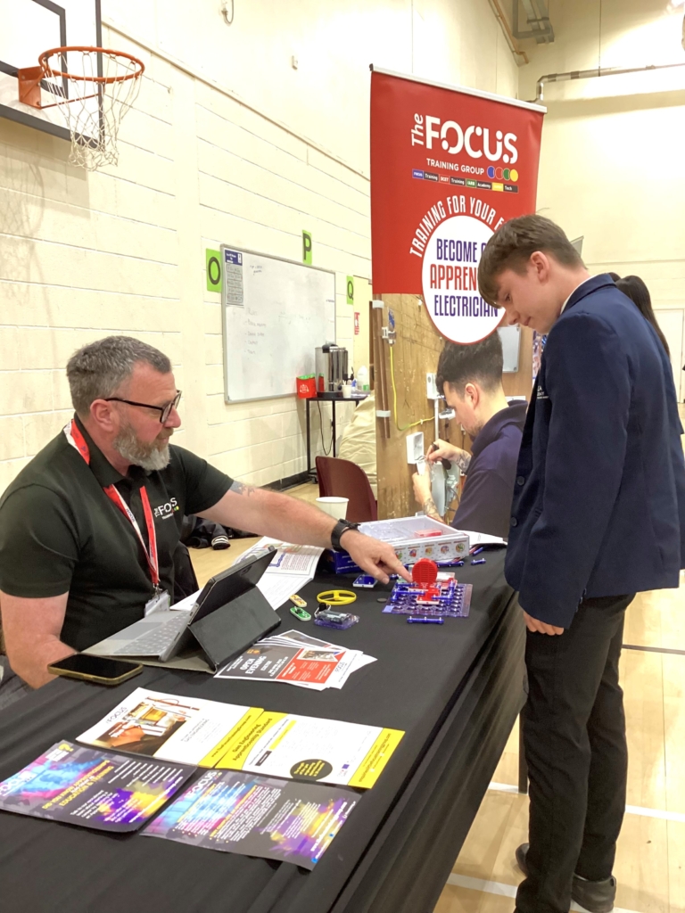 Students examining literature on table at careers fair