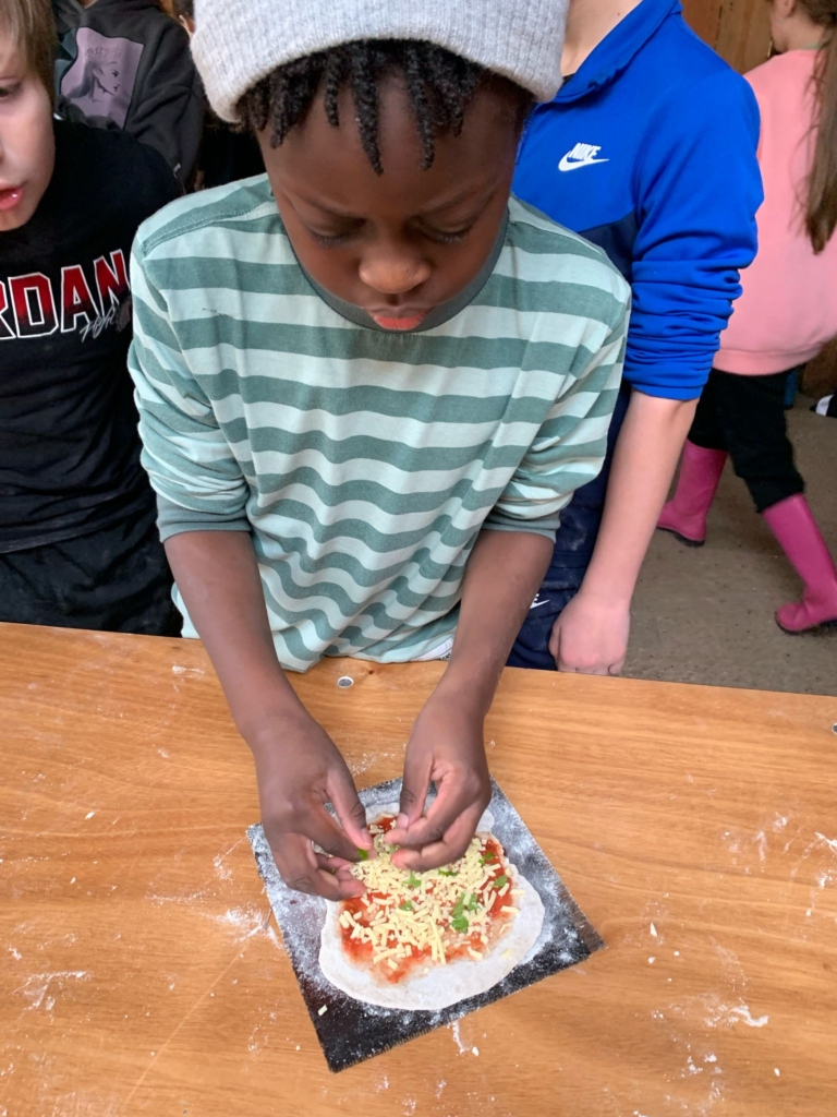 A pupil from Pupils from Whipton Barton Federation making pizza