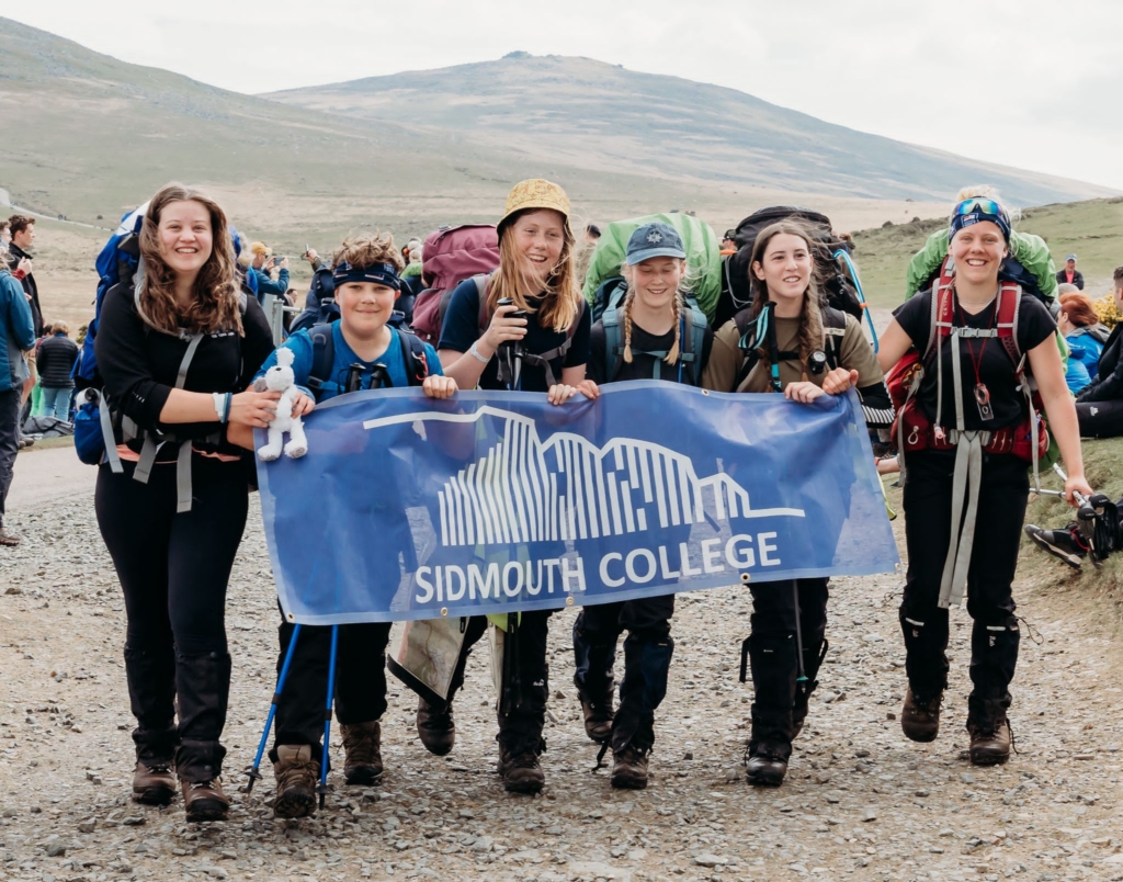 Sidmouth College Ten Tors Team walking with school flag