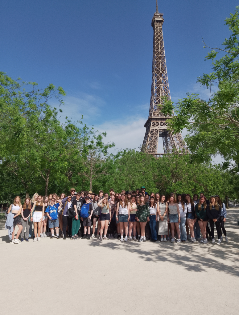Group of students stood posing in front of the Eiffel Tower