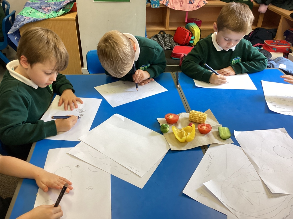 Children sat at a blue table drawing