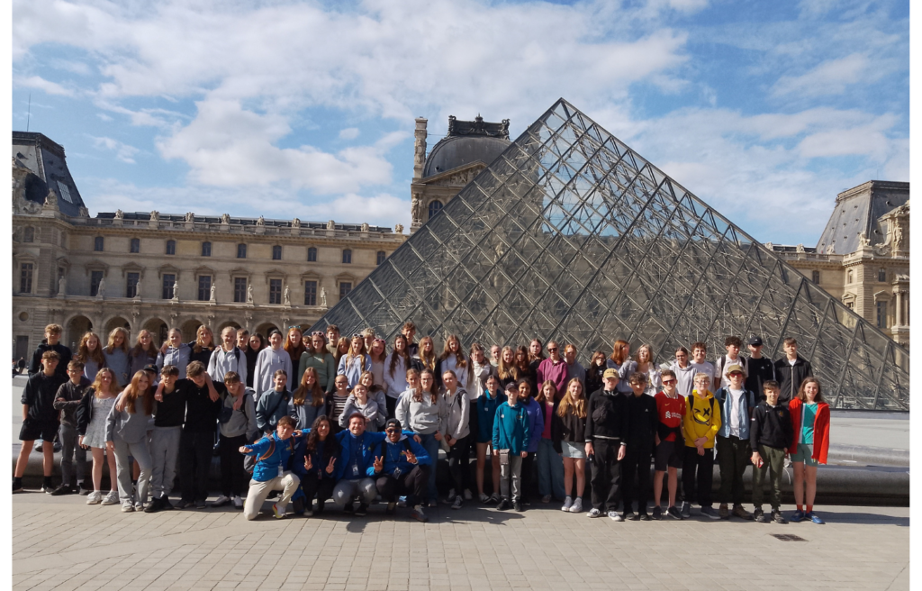 Group of students student posing in front of the Louvre
