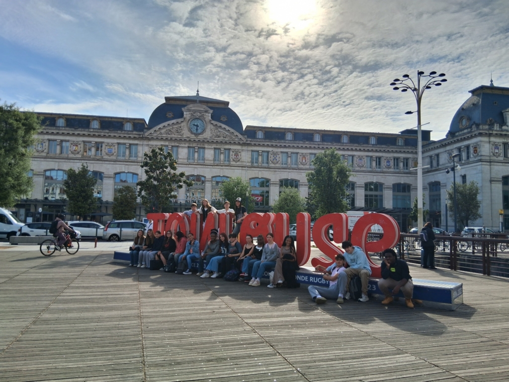 Students posing in front of a sign
