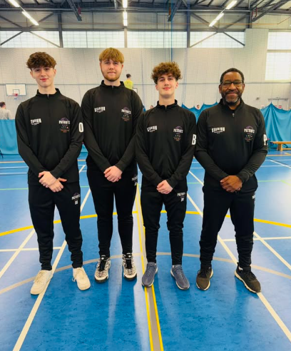 Three students and coach stood on basketball court