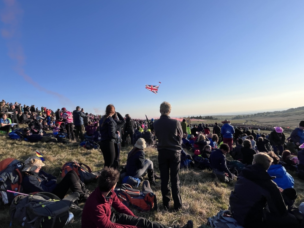 Start Flag for the Ten Tors 2025 with lots of students and staff sitting on Dartmoor