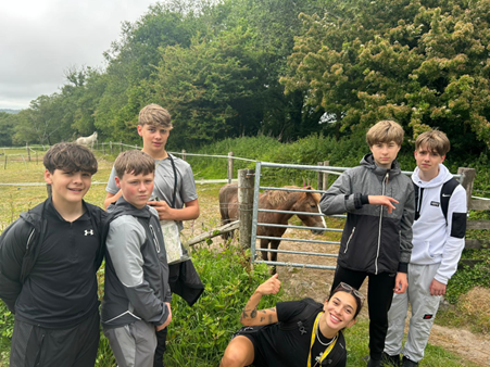 Four students stood posing with horse 