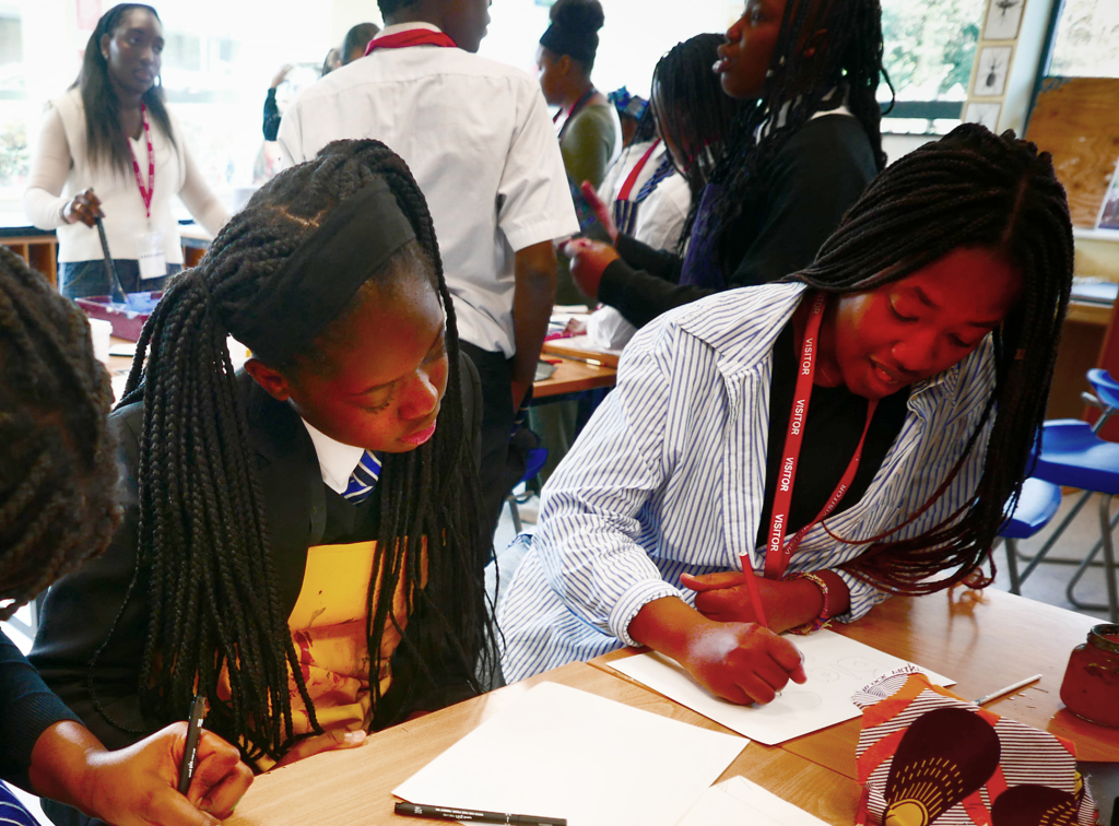 Two students sat at table drawing