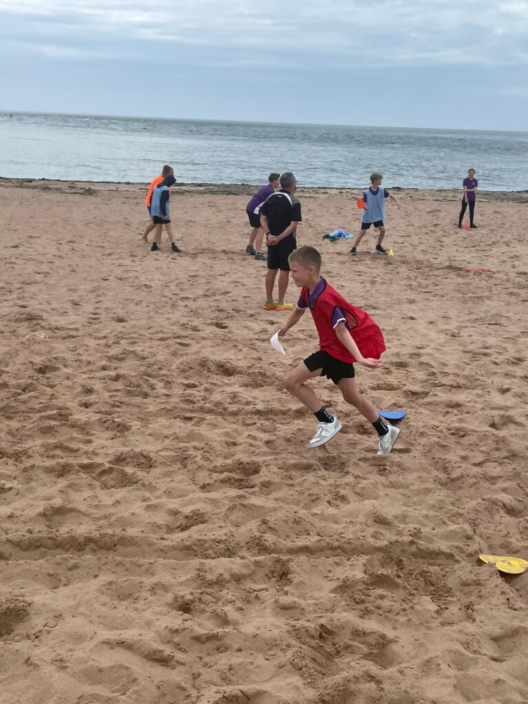 Students play games on the beach