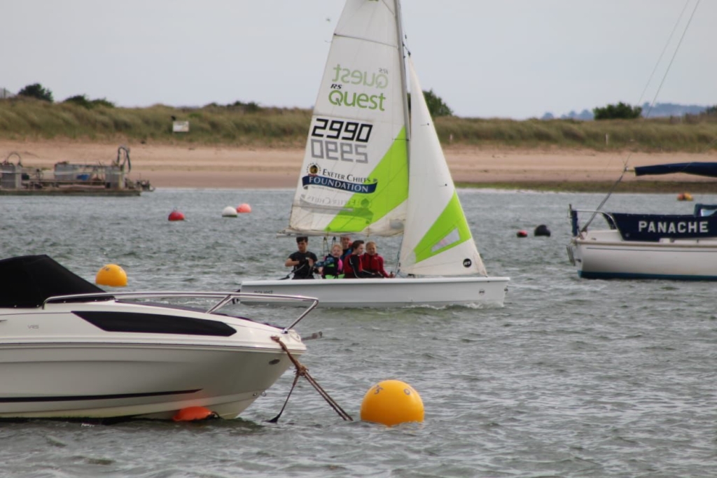 Photo of students sailing a white boat