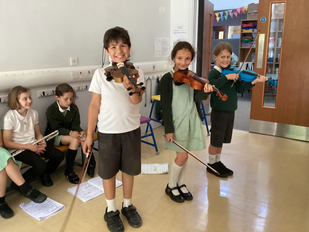 3 Exwick pupils stood up with musical instruments 