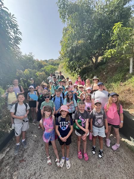 Students stood in a group on a path with trees each side facing the camera
