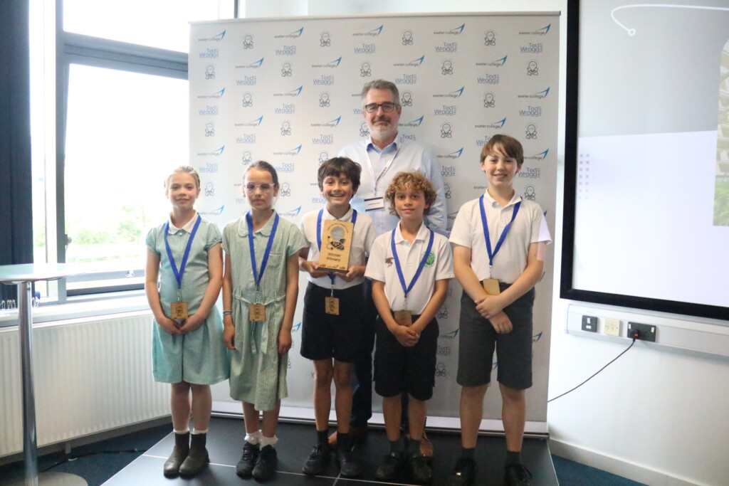 Five students stood smiling with medals around their neck