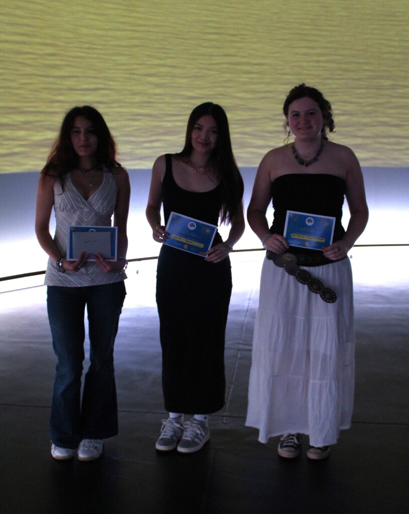 Three students stood holding certificates