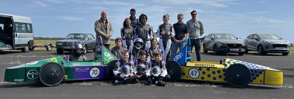GreenPower engineering and racing team stood next to race cars