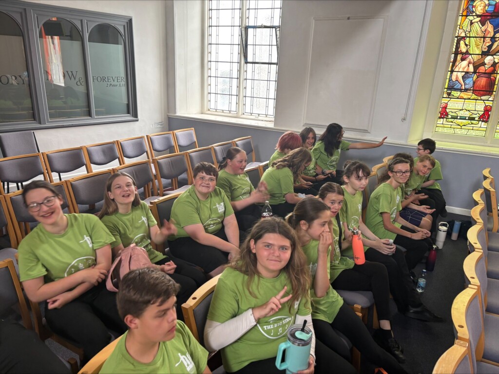 Two rows of students sat on chairs in church 
