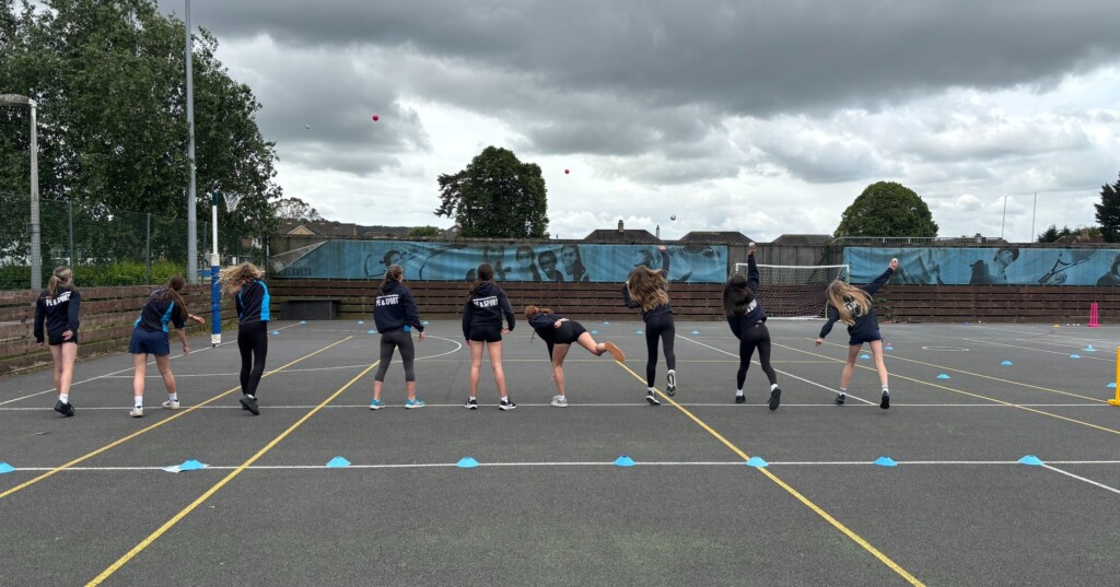 Honiton girls outside on court practicing cricket drills 