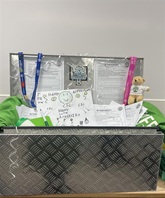 Silver metal box filled with papers, school teddybear and lanyards