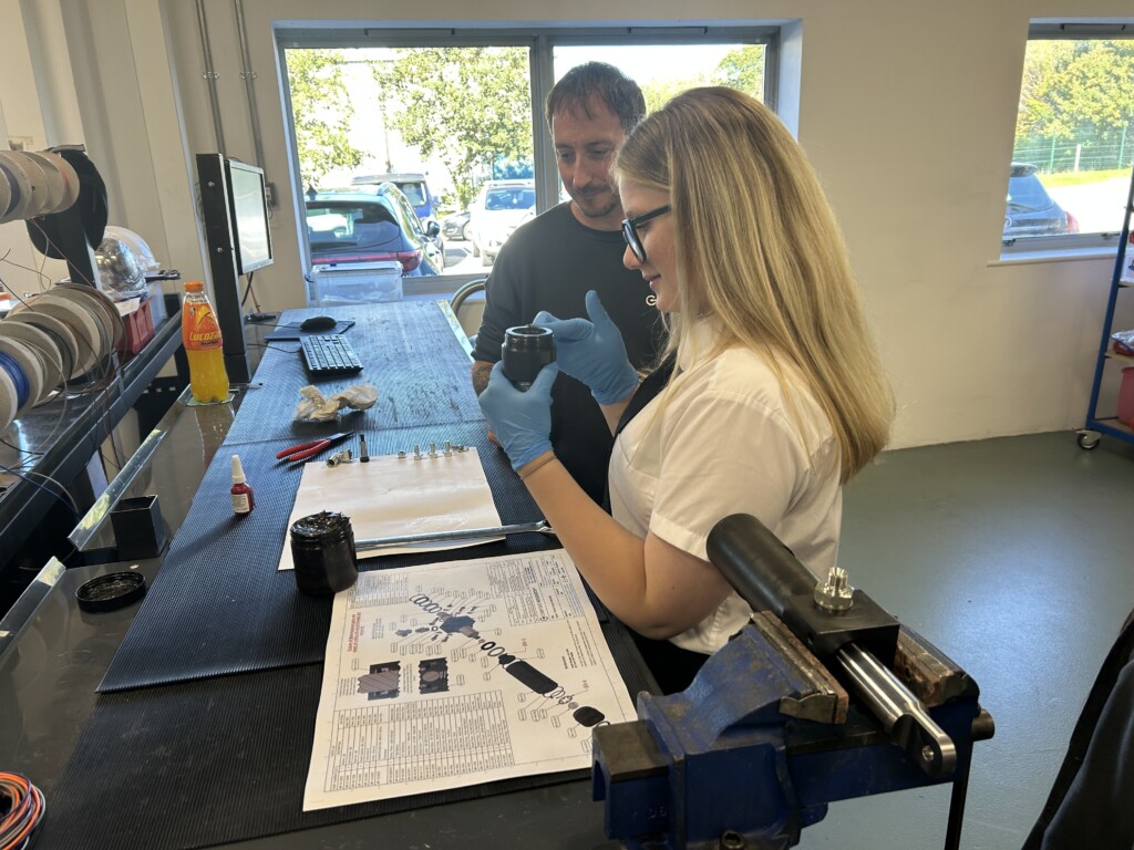 Student at a black workbench examining engineering equipment