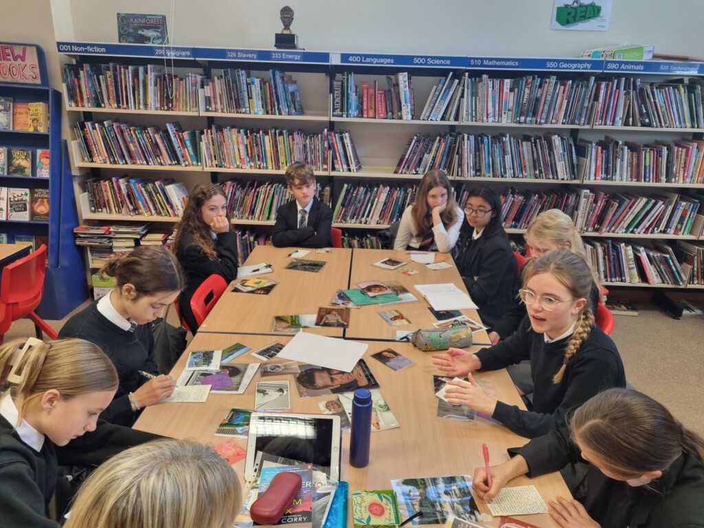Students sat around a table in a library talking to author