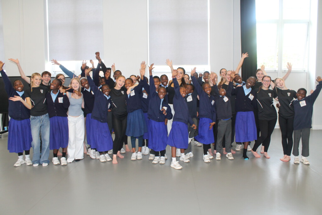Group of students smiling and waving at camera