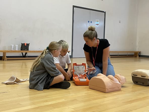 Year 4 Pupils sat next to a trainer in CPR workshop