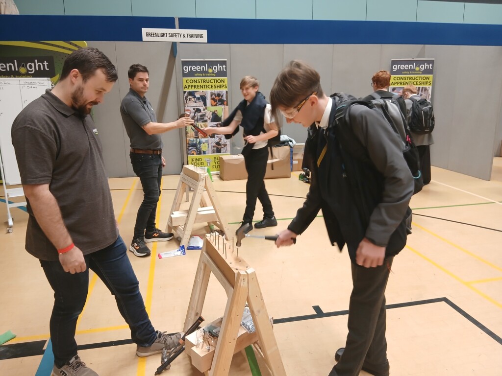 Student practicing using a hammer on a piece of wood