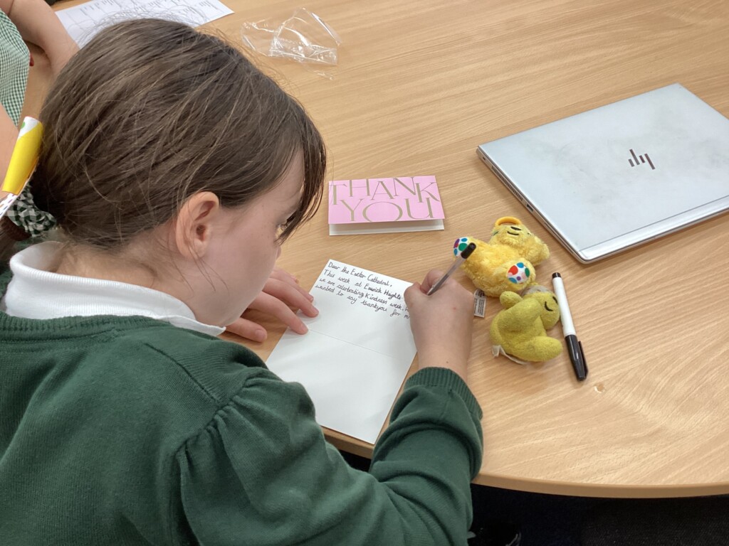 Child writing a card at a brown table
