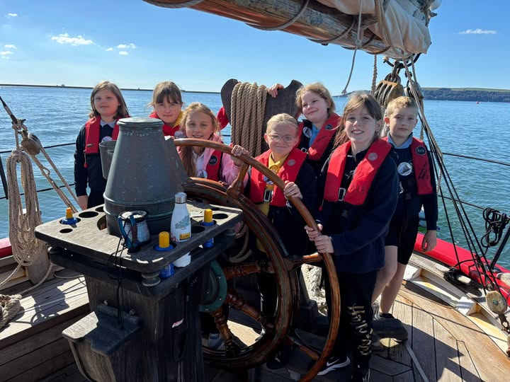 Marine Academy Pupils on a sailing boat, at the helm