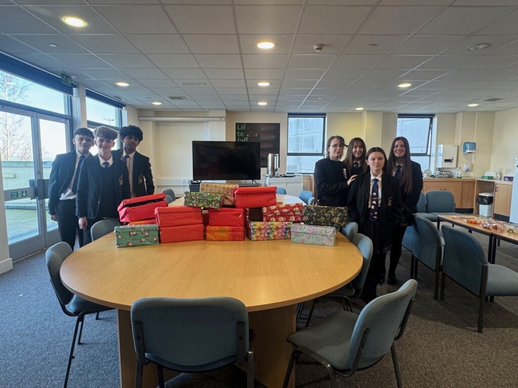 Students from St Luke's stood around a table with thier filled shoeboxes