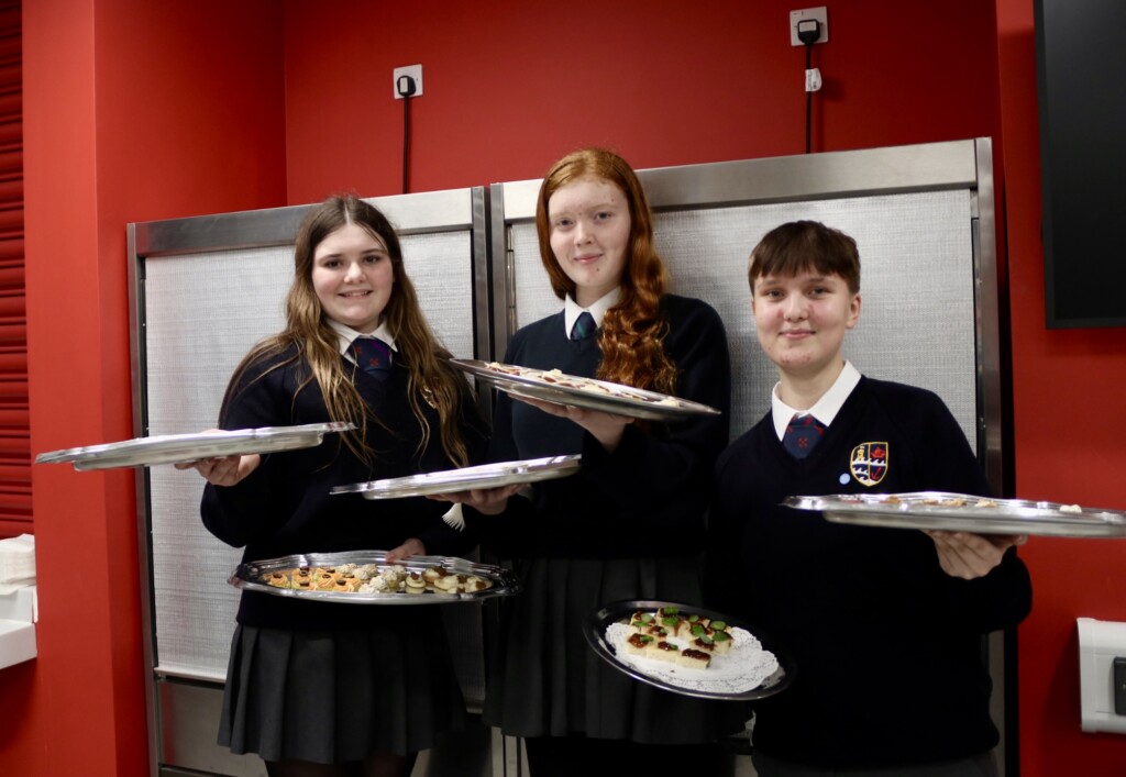 Exmouth students holding platters of food for the event