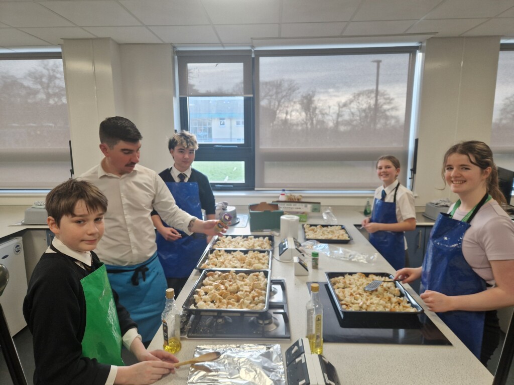 Students stood in kitchen preparing food