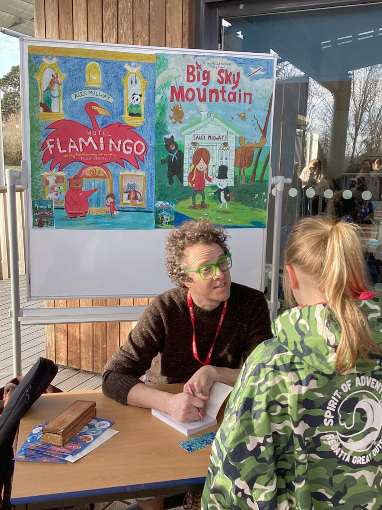 Alex Milway signing books and talking with a pupilat Exewick Heights