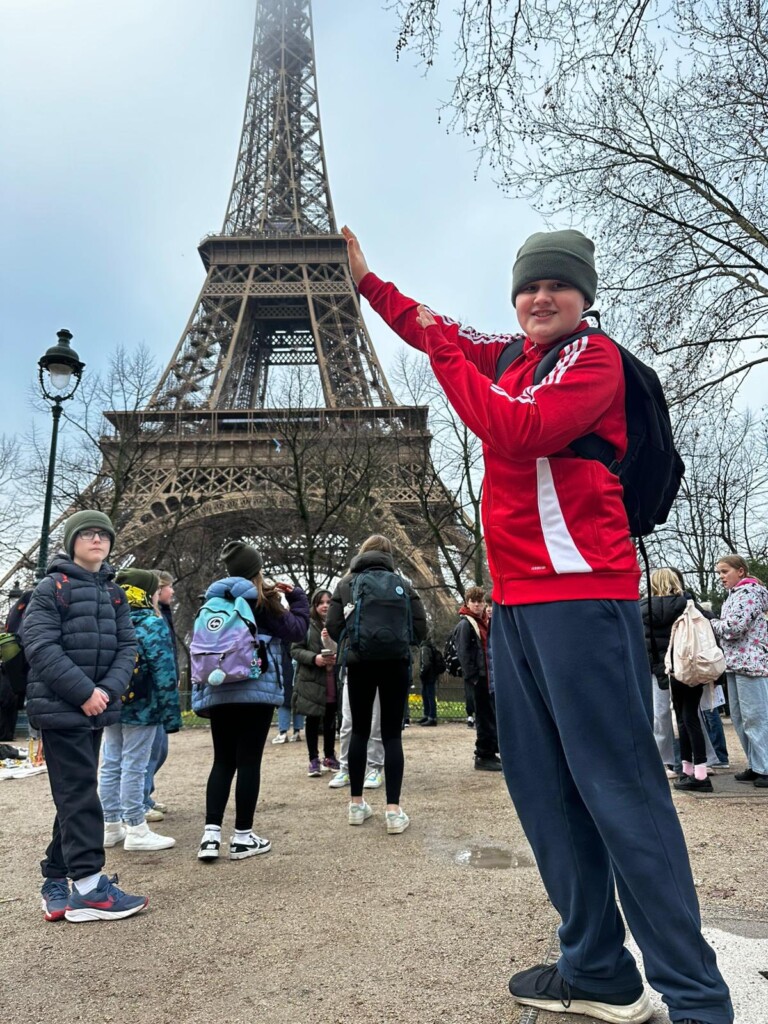 students holding up the eiffel tower