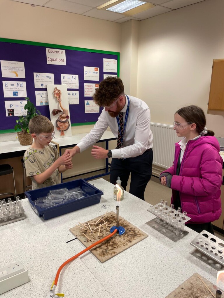 Teacher helping students in experiment