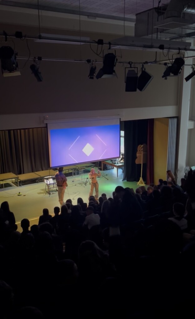 Singer Capri performing for students at Isca