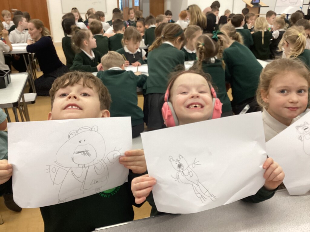 Children at Exwick Heights holding up their illustrations
