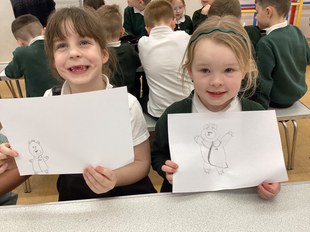 Children at Exwick Heights holding up their illustrations