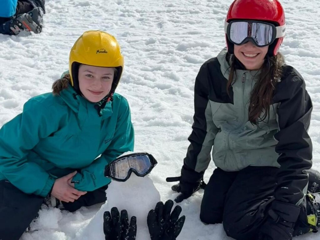 Isca Students making a mini snow man and sat on the snow in Spin