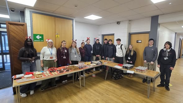 Lipson Students stading behin tables at their bake sale