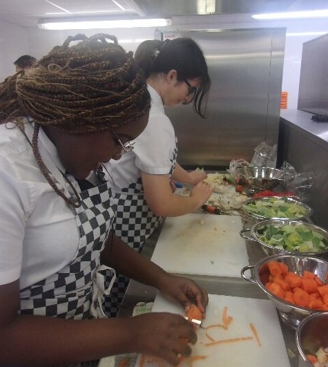 All Saints Students chopping veg in the kitchen