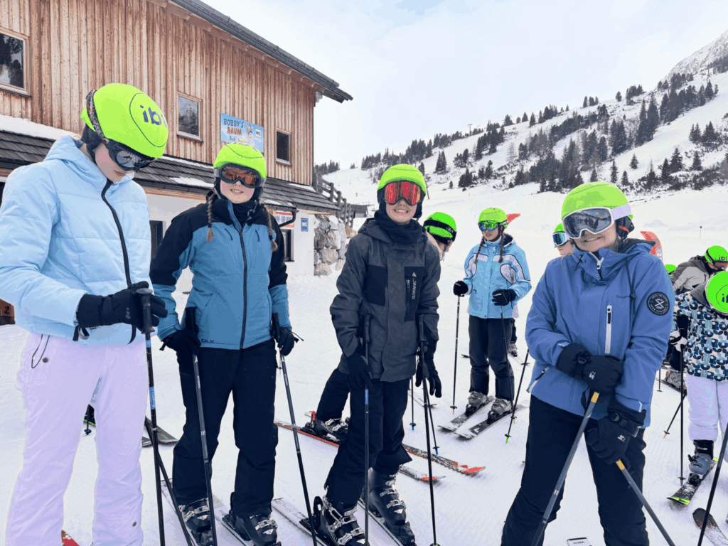 Students smiling at the camera in ski helmets